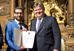 Staatsrat Schulz mit dem AVM-Schüler bei Ehrung im Rathaus